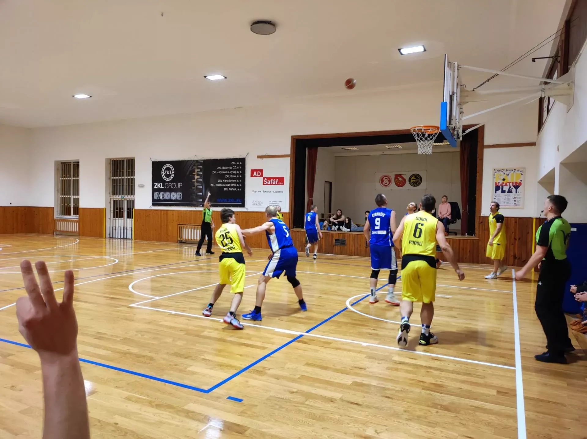 Muži B ve žlutých dresech v útoku proti soupeři v modrých dresech