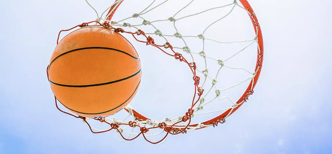 Basketbalový míč padá obroučkou do koše